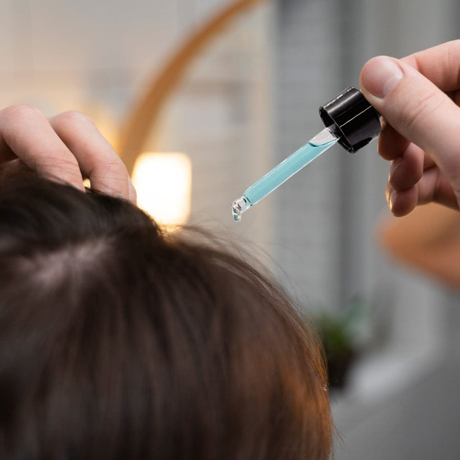 Applying Alvencia serum to the scalp with the dropper